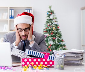 Wall Mural - Young businessman celebrating christmas in the office