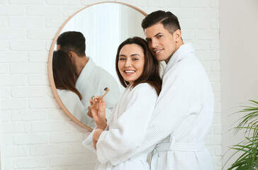 Sticker - Young couple brushing teeth with activated charcoal tooth paste in bathroom