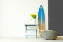 Surfboard, Table And Pouf Near Wall