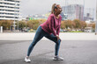 © Sabrina - Fit african senior woman doing sport stretching workout during rainy day in the city