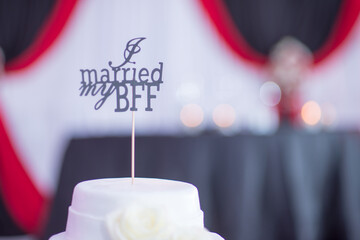 Wall Mural - Selective focus shot of a white wedding cake with a sign on it that says 