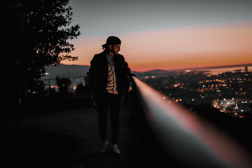 Sticker - Caucasian photographer taking photos at the sunset with a bokeh lights background