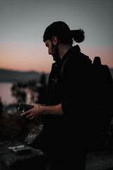 Sticker - Caucasian photographer taking photos at the sunset with a bokeh lights background