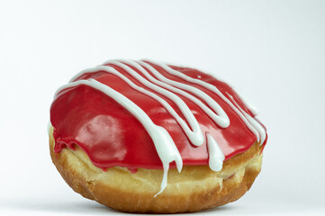 Poster - Closeup shot of a red donut with white glaze on top on a white background