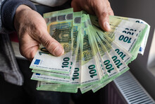 Close Up On Hands Of Unknown Caucasian Senior Man Holding And Counting 100 Euro Banknotes Money Wealth Insurance Payment Or Lifetime Savings Copy Space