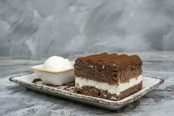 Poster - Slice of tiramisu and ice cream in a porcelain serving dish