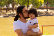 © Antonio Tanaka - portrait of a Hispanic father and baby in a park smiling and having fun