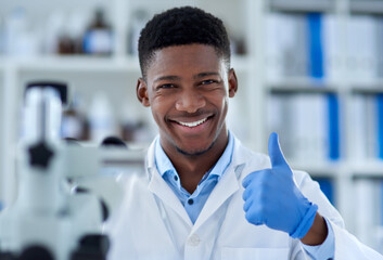 Poster - A job well done. Portrait of a cheerful young male scientist wearing protective gloves while showing thumbs up inside of a laboratory during the day.