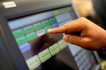 Closeup photo of a person using a till.
