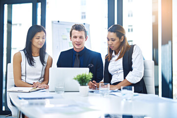 Poster - Effective collaboration makes the results better. Cropped shot of a group of young businesspeople having a discussion while using a laptop in a modern office.