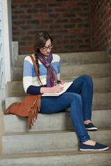 Poster - Working hard to secure a bright future. Shot of a university student writing in her notebook on campus.