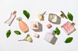 Bottles of floral perfumes on light background, top view