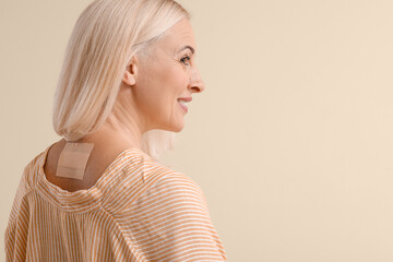 mature woman with applied nicotine patch on color background. smoking cessation