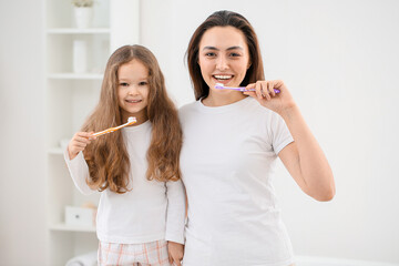 Canvas Print - Little girl with her mother brushing teeth in bathroom