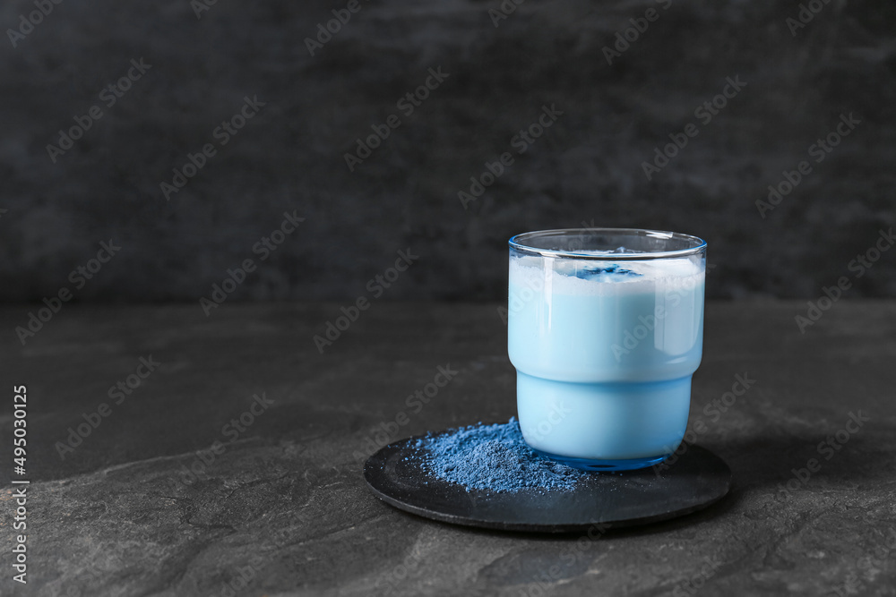 Glass of blue matcha tea on dark grunge background
