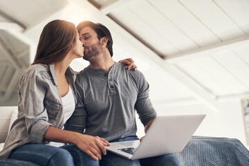 Wall Mural - Snogging before we start blogging. Shot of an attractive young couple spending quality time at home.