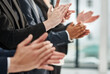 Great presentation are motivational. Closeup shot of a group of executives clapping while standing in a row in an office.