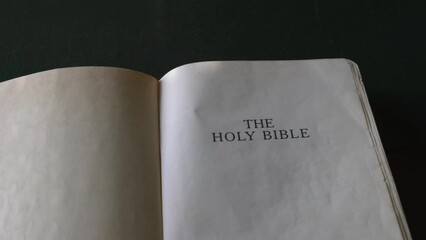 Wall Mural - Holy Bible on table, open page. Close up and pan shot.