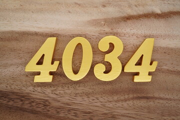 Golden Arabic numerals on a real brown and white wooden floor number 4034