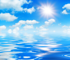 Wall Mural - sunny day background, blue sky with white cumulus clouds and glaring sun over sea water