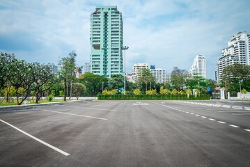 Empty space large outdoor asphalt car parking lot in city with city building background. Transport concept.