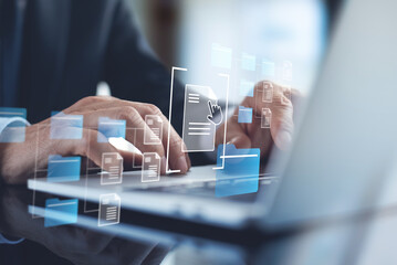 Document Management System (DMS) being setup by IT consultant working on laptop computer in office. Software for archiving, searching and managing files and information