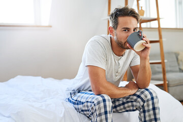 Aufkleber - The day doesnt start until that first sip. Shot of a handsome young man drinking coffee in bed at home.