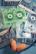 Stack of transparent audio cassettes with orange headphones
