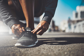Wall Mural - The best project youll ever work on is you. Shot of a sporty man tying his laces before a run.