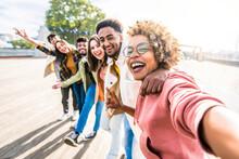 Multiracial Friends Group Taking Selfie Pic With Smartphone Outside - Happy Young People Having Fun Walking On City Street - Friendship Concept With Guys And Girls Enjoying Summertime Day Outside
