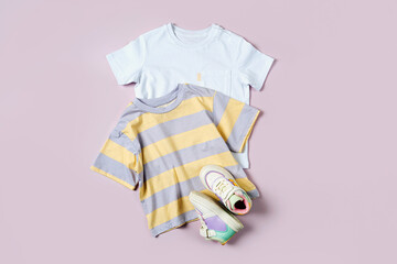 Wall Mural - T-shirt  and sneakers. Baby clothes and accessories for spring, autumn or summer on pink background. Fashion kids outfit. Flat lay, top view