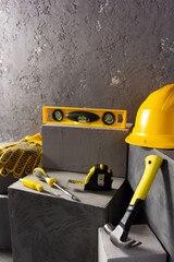 Canvas Print - Construction tools and concrete cube  on brick abstract background texture