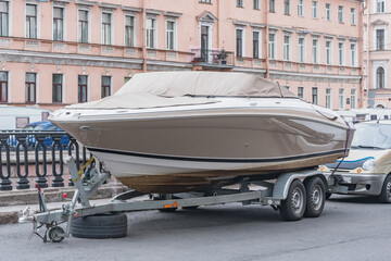 Motor boat on the trailer on the city street.