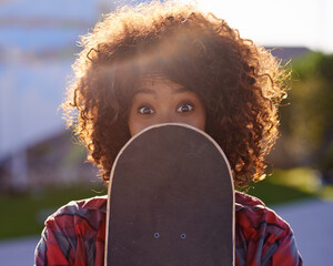 Canvas Print - A little fun in the skate park. A young woman with a quirky expression holding her skateboard.