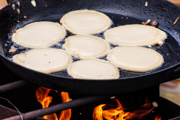 Wall Mural - Blini, blin or blynai, pancakes traditionally made from wheat or buckwheat flour and served with smetana, tvorog, butter, caviar and other garnishes, preparing outdoor on an open fire