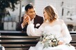 © anatoliycherkas - An international wedding couple, a European bride and an Asian groom walk around the city together.