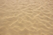 Beige sand textured background. Wavy pattern from the wind. Top view