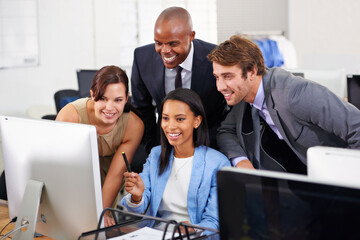 Poster - They work well as a team. Shot of a group of businesspeople working around a computer.