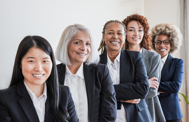 multiracial business women smiling on camera inside modern office