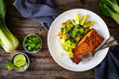 Fried teriyaki salmon steak with pak choi and lime on wooden table

