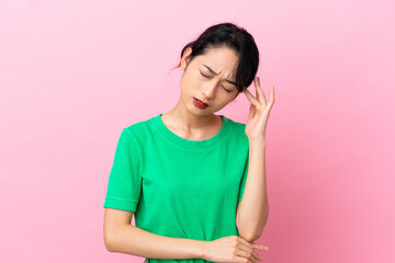 Wall Mural - Young Vietnamese woman isolated on pink background with headache