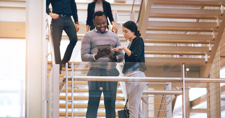 Poster - Theyve found the right app to work with. Cropped shot of two young businesspeople using a digital tablet while standing in a modern workplace.