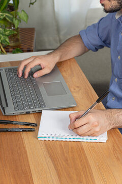 Office worker writes and annotates while working in his office.