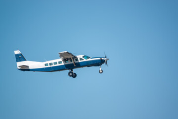 Cessna 208B Grand Caravan light aircraft ascends from takeoff in a clear blue sky