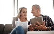 © T Hinrichsen/peopleimages.com - Couples who save together go on vacation together. Shot of a mature couple using a digital tablet while going through their paperwork together on the sofa at home.