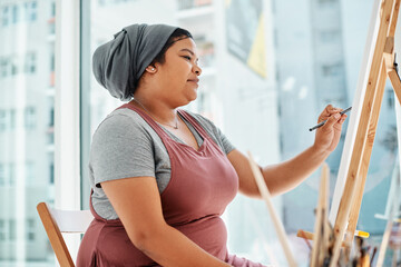 Getting the sketch just right before I paint. Cropped shot of an attractive young artist sitting alone and painting during an art class in the studio.