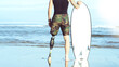 Caucasian surfer man with an artificial leg, looking at the sea and holding a surfboard, Concept of overcoming,