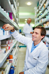 Poster - Filling your prescription like the pro that he is. Shot of a young pharmacist doing inventory in a pharmacy.