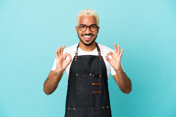 Canvas Print - Restaurant Colombian waiter man isolated on blue background showing an ok sign with fingers