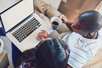 Aufkleber - Doing some online browsing for decor ideas. High angle shot of a young couple using a laptop while moving house.